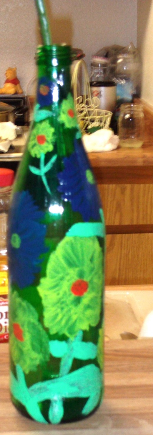This vibrant hand painted vase makes a green and earth friendly gift!  I recycled a glass bottle by creating this gift for my mom, and I did not have to spend an extra money.  This vase with created with supplies I had around the house.