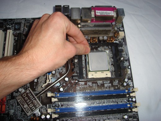 Pushing down the silver lever to secure the processor in place