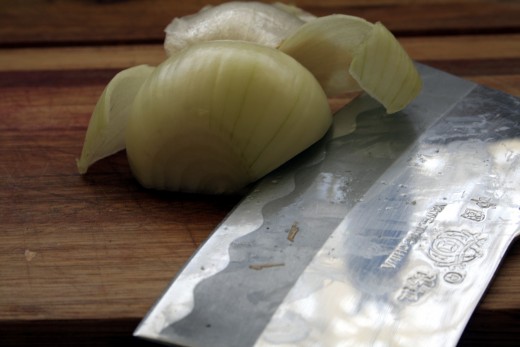 Step 4. Cut the onion on the guide lines, holding the knife at 90 degrees to the onion. Do not cut all the way to the root stop about a finger width away.