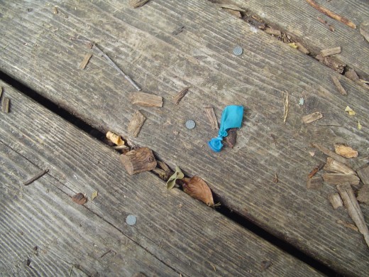 A bright blue baloon next to metal nails.