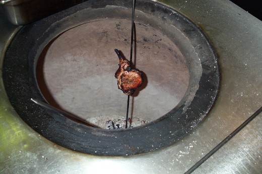 Tandoori Oven Made Of Clay. Iron  skewers are placed with marinated meat /chicken over live coals