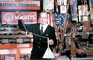Orville Carlisle with a model rocket in back of his Norfolk, Nebraska shoe store. This place also served as his little pyrotechnic museum cum workshop.