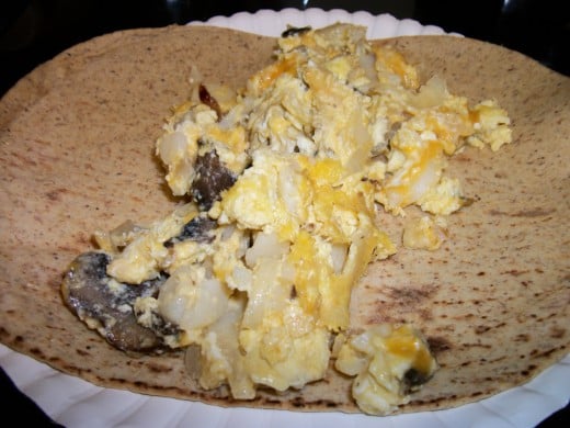 Breakfast taco with eggs scrambled with onions, mushrooms, potatoes, and cheese. 