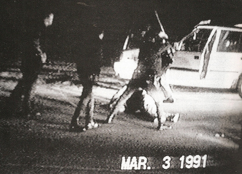 This photo take out of a video shows Rodney King on the ground being bludgeoned by some police officers for a traffic violation.