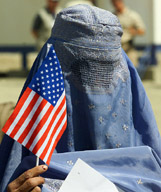 A burkha clad Afghan woman holds a US flag at a ceremony in Kabul on Monday. The ceremony was organised by the Wheelchair Foundation, a US-based NGO, to mark the donation of over 5000 wheelchairs to Afghanistan. — Reuters
