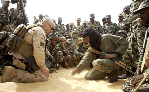 A U.S. Special Forces soldier instructs Malian troops in counterterrorism tactics on the outskirts of Timbuktu. Photographs by Justin Bishop (2007).  