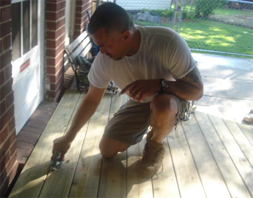 Scrubbing rough edges from a nealy built wood ramp; preparing for the stain.