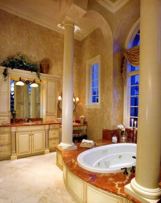 beautiful marble bathroom with cream, antique cabinets, high ceilings, pillars and various marble finishes throughout - elegant and impressive