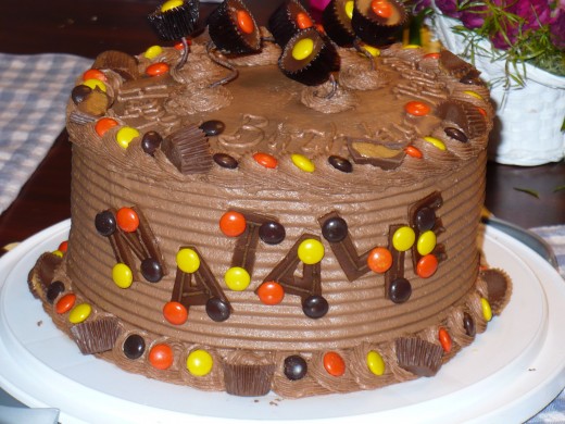Reese's candy cake.  M&Ms and Reese's are perfect for borders.  The cups on top are just on wires that were covered with floral tape, curled around a pencil, and stuck into the cake.  The letters are dried chocolate fondant. 