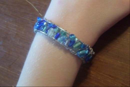 Cuff bracelet made with a variety of sea glass, a wire frame, and wire. 