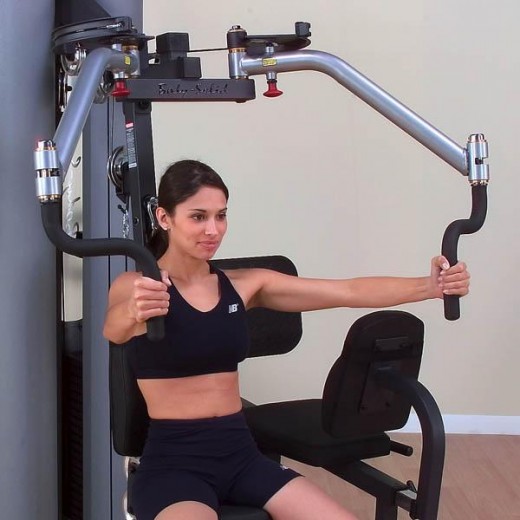 young brunette girl demonstrating the Pectoral Fly Land Exercise Machine