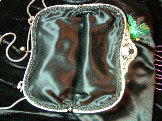 the inside lining of the purse also showing the trim to cover the stitching holes. 
