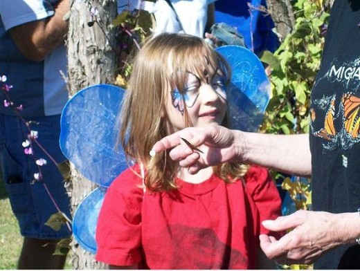 Linda Schemmer demonstrates how to hold the fragile butterfly for tagging before it is released. The tiny tag is on her forefinger as Linda explainsl how to apply it.