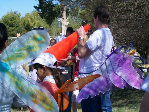 Butterfly wings surround the announcer as he is going to call out the name of a child who gets to release a butterfly.  His own purple wings were a sight to admire!