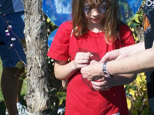This lucky girl carefully prepared to tag a Monarch before she helps release it.
