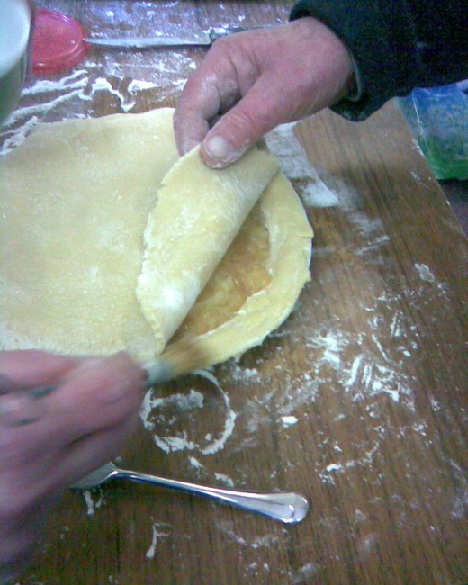 use pastry brush to ad water round edges and place top of pie over dish
