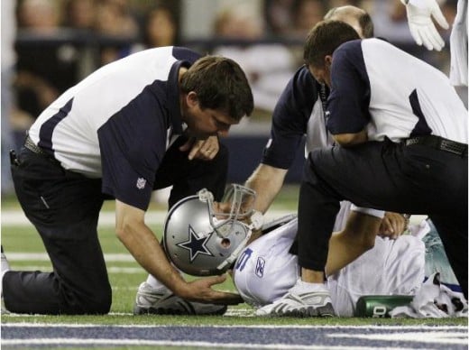 Dallas Cowboys quarterback Tony Romo is tended to during the first half of against the New York Giants in an NFL football game Monday, Oct. 25, 2010, in Arlington, Texas. Romo was drilled into the turf on his left shoulder, forcing him to the locker 