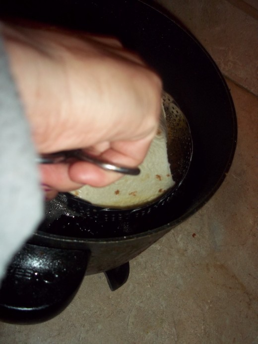 Using Tongs to gently and safely lower basket into hot oil.