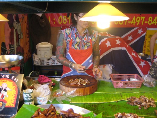 A beautiful tattooed lady butchering stewed pork - I wonder if she's single.
