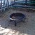Fire pit and wooden benches for seating.