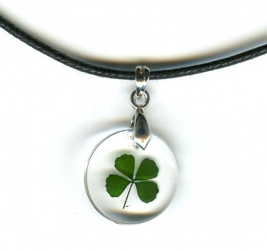 This beautiful Celtic necklace contains a genuine four leaf clover frozen in clear acrylic polyresin suspended on a black cord necklace. Pendant is about the size of a dime.