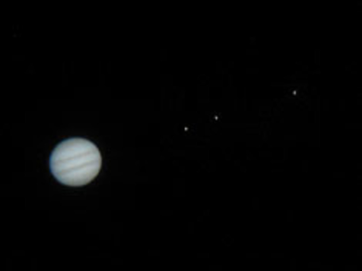 The planet Jupiter as viewed through a small telescope. Notice tiny pinpoints of light to the right of its disk. These are three of the galilean satellites or moons.