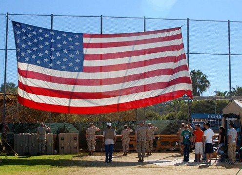 The Military, Civilians and Homeless salute the U.S. Flag, during stand down for homeless veterans. 