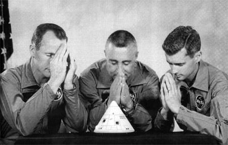 The astronaut team prayed over a model of the Apollo I, having voiced vital concerns about fire hazards. They did, in fact, perish in a fire inside the capsule, suffocating because the hatch locked from the outside. They could not be reached in time.