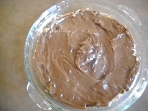 Brownie batter spread out completely covering the peanut butter cookie dough.
