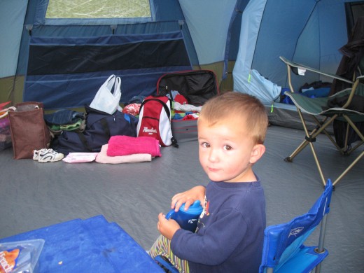 My youngest son, sitting in the centre of the lounge area.  This is the best photo I have of the inside, sorry.  If I had known that one day I would be writing a hub about the tent, I would have been sure to take more photos.