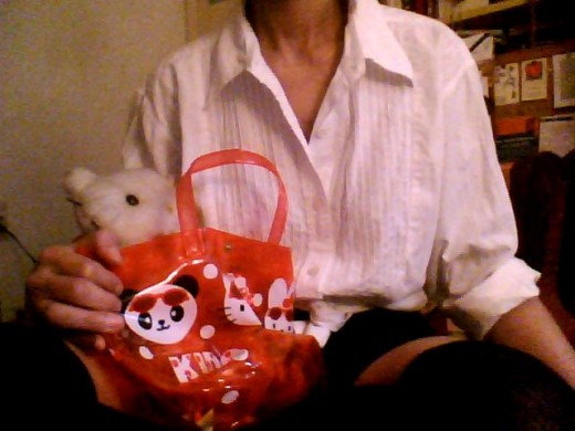 This is me holding my Hello Kitty bag and Hello Kitty plush doll.