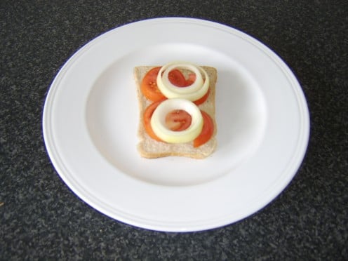 Tomato and onion slices are placed on the bread