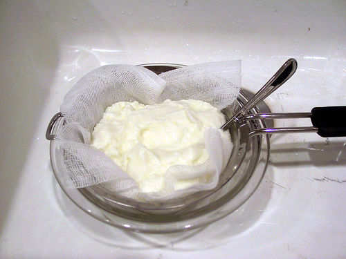 Straining yogurt to yield thick, rich Greek-style yogurt