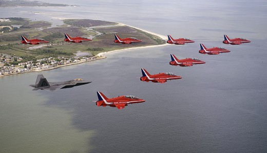  F-22A Raptor Demonstration team pilot, flies in formation with British Royal Air Force Aerobatic Team, The Red Arrows, during an afternoon practice flight.