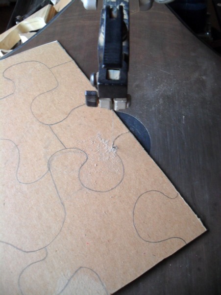 Use a scroll saw to cut the puzzle in to pieces.