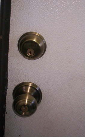 New locks look good. In fact,they look TOO GOOD. Now I have to go back to the hardware store and buy some white paint for the door. 