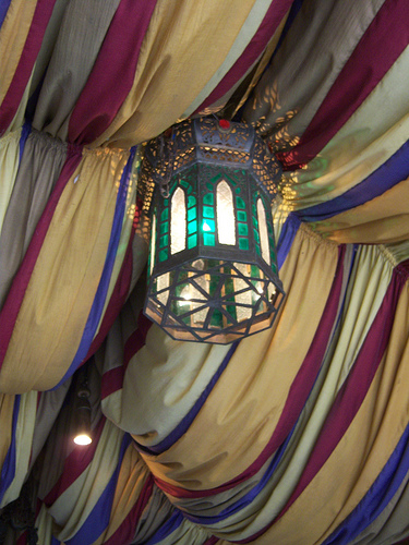 Soft but colorful lanterns emerge from lush draped material hanging overhead. CC lic: http://bit.ly/ItuRo