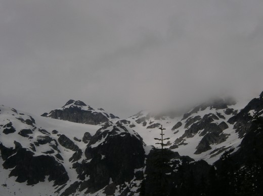 More clouds and a cold wind. See the black rock cliffs below the upper glacier.