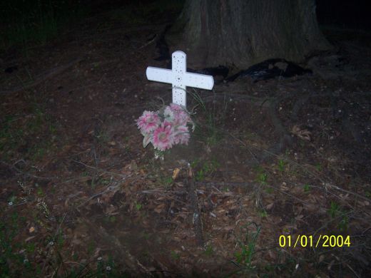 The flowers are still there but the cross was taken. Exactly why or when I don't know. 