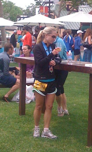 A racer re-hydrates and celebrates with some wine after a wine country half marathon