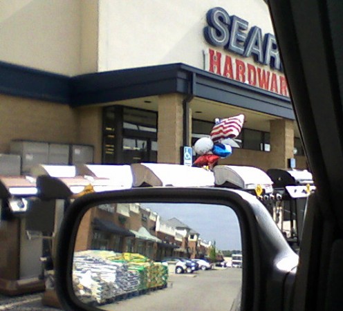 This bunch of balloons over outdoor grills on sale is the only decorating this store did for Memorial Day. You can see the gardening mulch in the side view mirror.