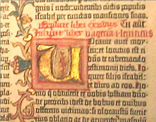 A gold-leafed illumination from the Gutenberg Bible. The designs at the left continue upward and downward in the margin. The red letters above the design is called "rubrication."