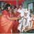 A scene from a south Indian hindu wedding.(observe the grand designs on the red saree ofthe greeting lady) A scene from a south Indian hindu wedding.(observe the grand designs on the red saree ofthe greeting lady)