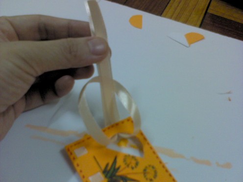 Then poke the 2 ribbon tails thru the ribbon hole.