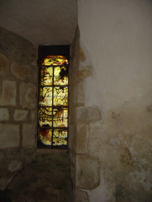 The chapel is lit by a small window with stained glass.