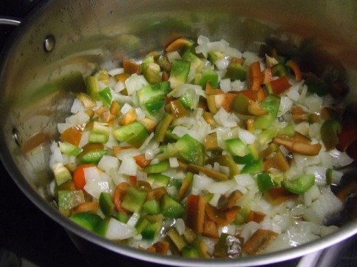Chop the onion, garlic,  and peppers. Saute' in vegetable or olive oil in a 6 quart dutch oven.