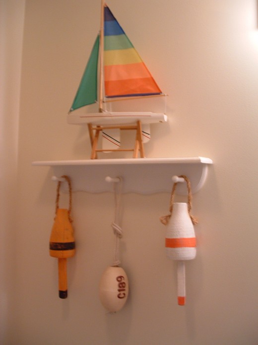 Hand Painted Craft Buoys Hanging From  Our Bathroom Shelf