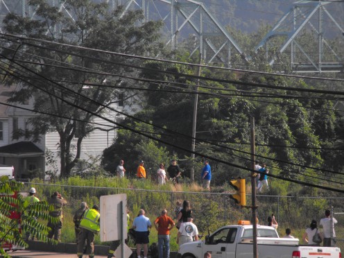 Onlookers away the blast to send the bridge into the river below.