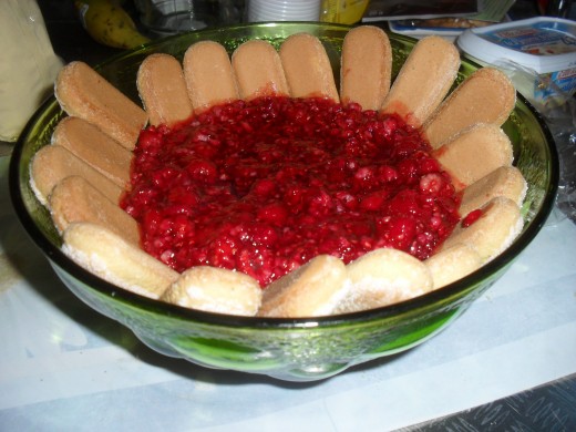 Preparing the raspberry pudding with ladyfinger biscuits