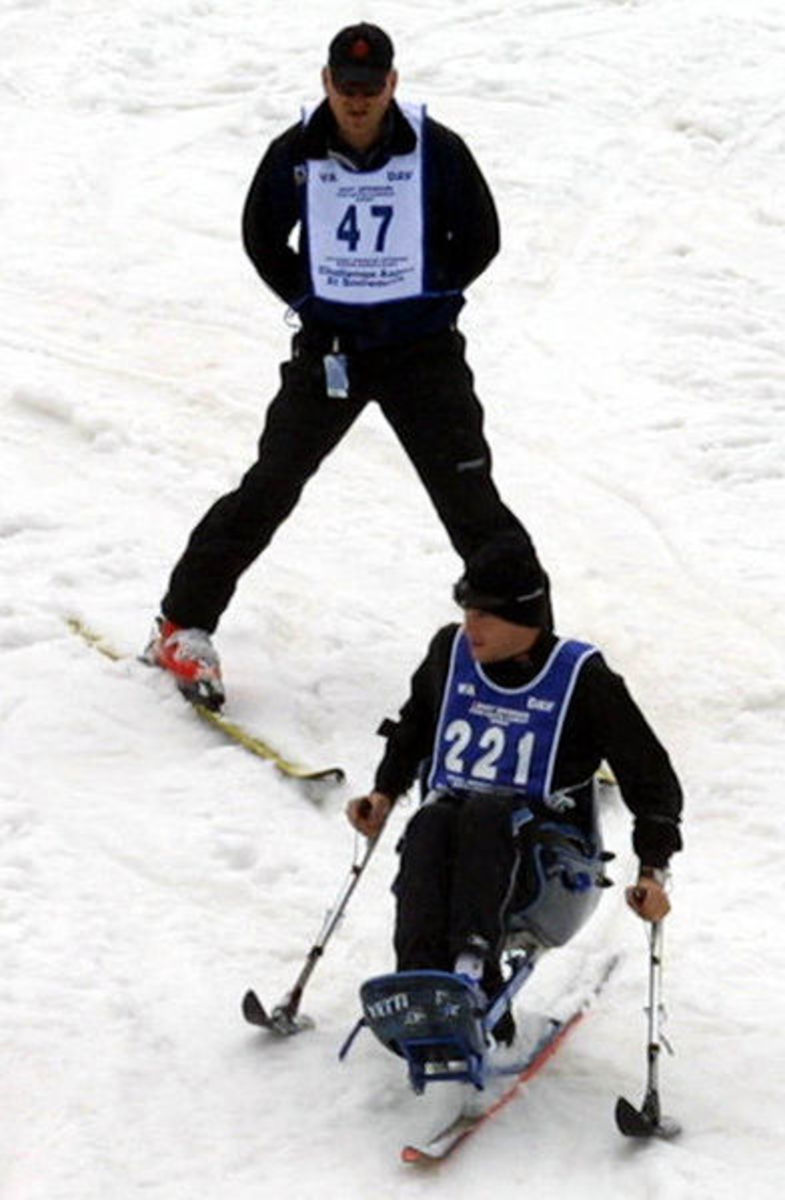 Cpl. Brian Wilhelm uses a mono-ski at the annual National Disabled Veterans Winter Sports Clinic, April 4-9 at Snowmass Village CO. Capt. David Rozelle, behind him, lost his right foot after a land mine explosion.  